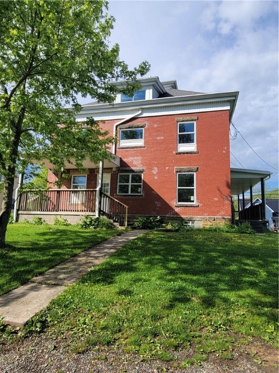 rear view of house featuring a yard