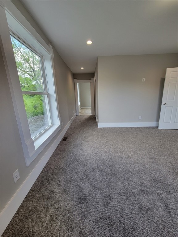 spare room with dark carpet