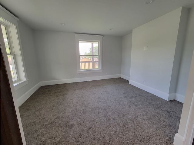 unfurnished room with dark colored carpet