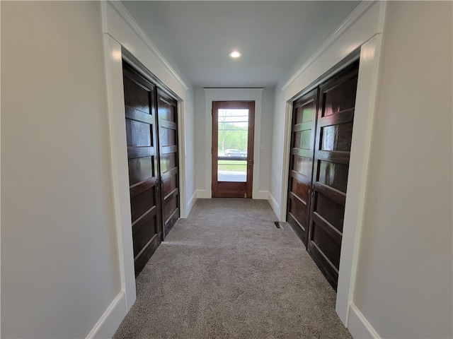 entryway featuring ornamental molding and carpet flooring