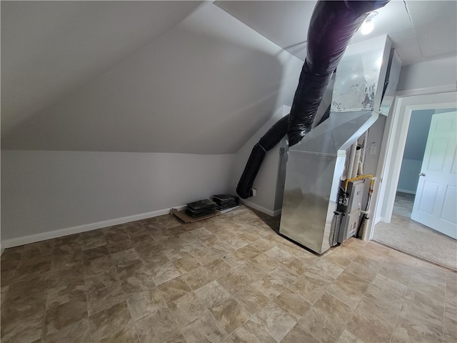 bonus room featuring vaulted ceiling, light tile floors, and heating utilities