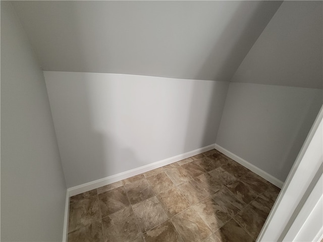 bonus room with tile floors and vaulted ceiling