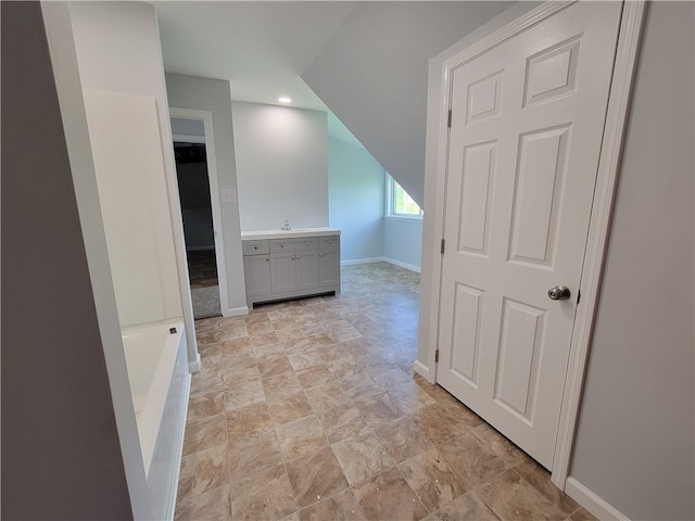 hallway with sink and light tile flooring