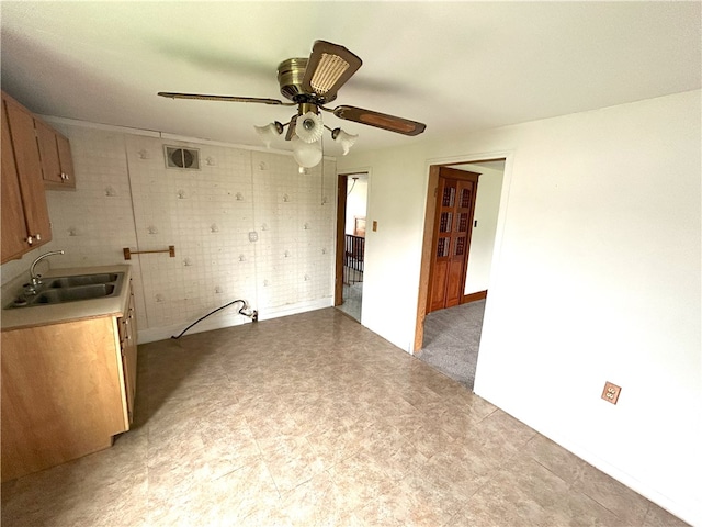 kitchen featuring sink, ceiling fan, and light tile floors