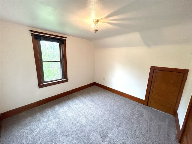 spare room featuring lofted ceiling and carpet