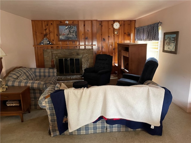 carpeted living room featuring a fireplace and wooden walls