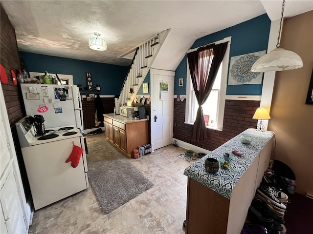 kitchen with white appliances, hanging light fixtures, and light tile flooring