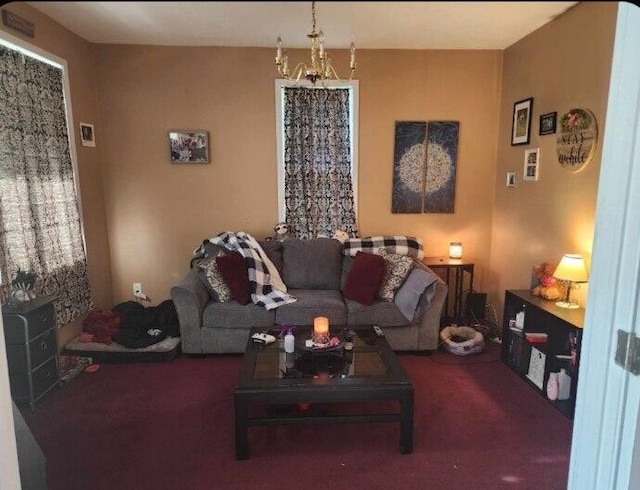 carpeted living room featuring a notable chandelier