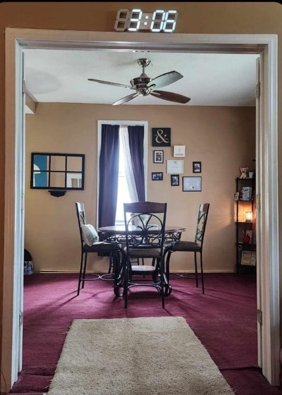 carpeted dining space with ceiling fan