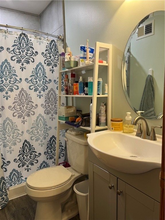 bathroom with hardwood / wood-style flooring, a shower with curtain, vanity, and toilet