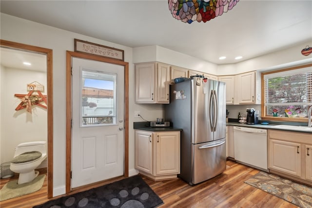 kitchen featuring stainless steel fridge, sink, wood-type flooring, and dishwasher