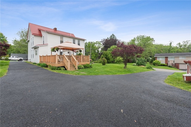 view of front of property with a wooden deck and a front lawn