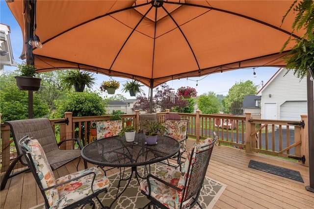 wooden deck with a garage and a gazebo