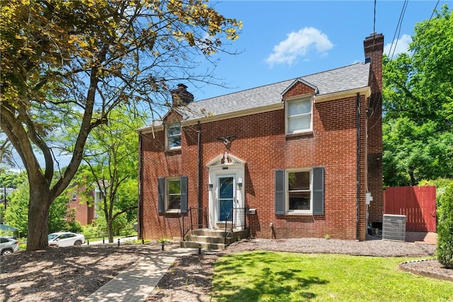 view of front of property featuring a front yard and central AC