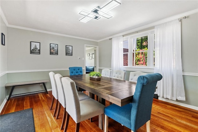 dining area featuring hardwood / wood-style floors and ornamental molding