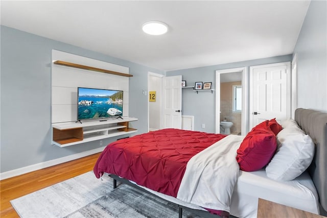 bedroom with hardwood / wood-style flooring and ensuite bath