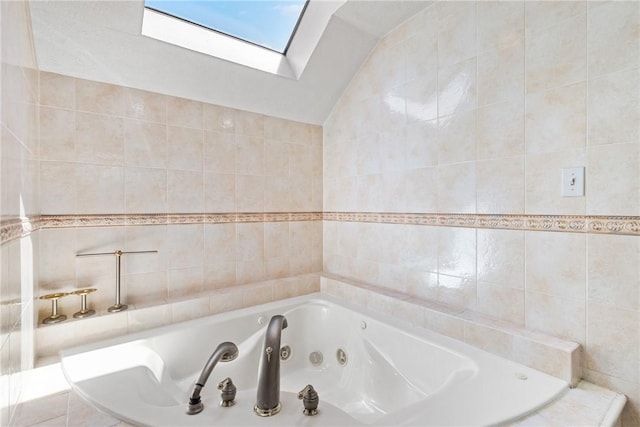 bathroom with lofted ceiling with skylight, tile walls, and tiled tub