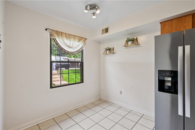 kitchen with light tile flooring and stainless steel fridge with ice dispenser