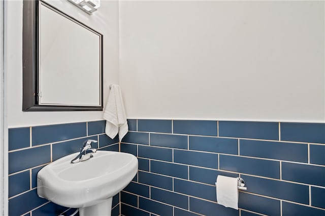 bathroom featuring backsplash, sink, and tile walls