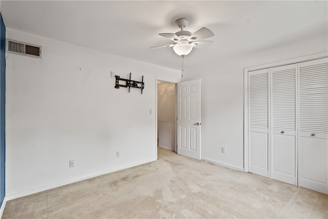 unfurnished bedroom featuring a closet, ceiling fan, and light colored carpet