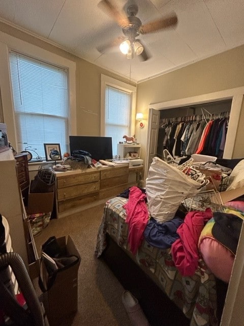 bedroom with multiple windows, a closet, carpet floors, and ceiling fan