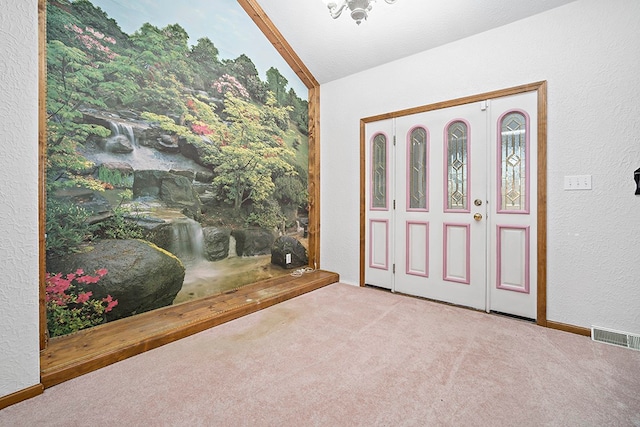 carpeted entrance foyer with vaulted ceiling