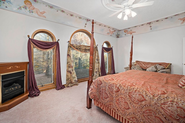 carpeted bedroom featuring ceiling fan and a textured ceiling