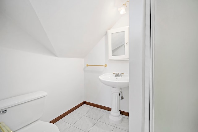 bathroom featuring tile floors, toilet, and vaulted ceiling