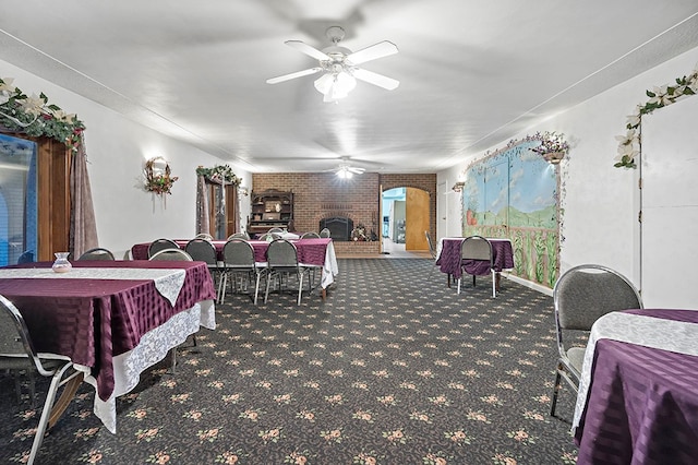 bedroom with carpet flooring, brick wall, ceiling fan, and a fireplace