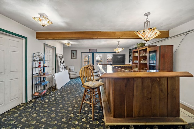 kitchen featuring decorative light fixtures, beamed ceiling, and carpet floors