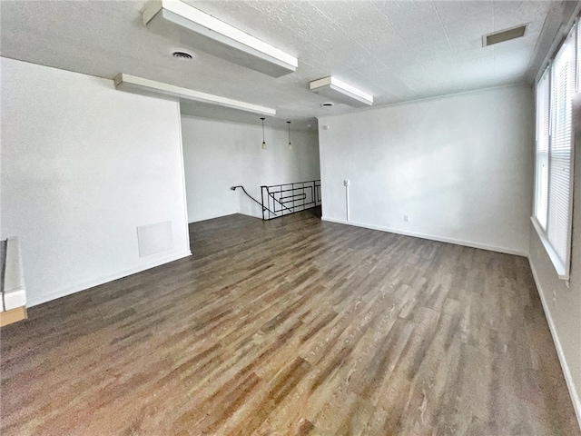 spare room featuring wood-type flooring and a textured ceiling