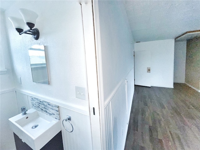 bathroom featuring sink, backsplash, and wood-type flooring