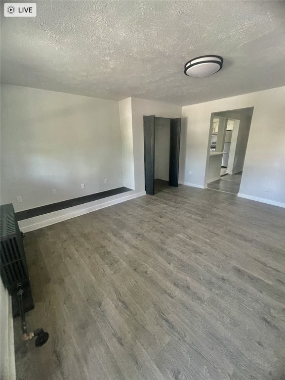 empty room featuring wood-type flooring and a textured ceiling