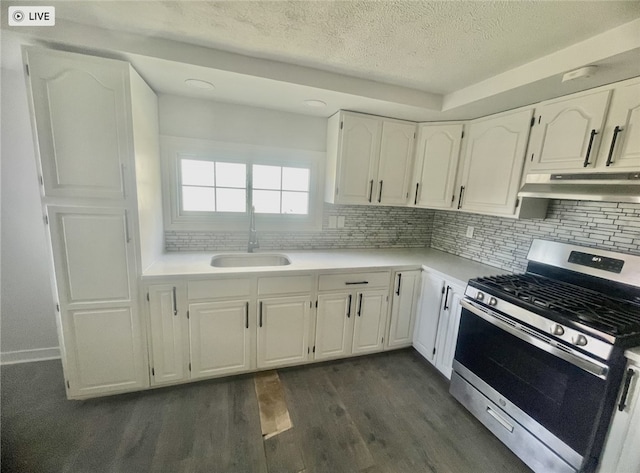 kitchen with tasteful backsplash, dark wood-type flooring, gas stove, sink, and white cabinetry