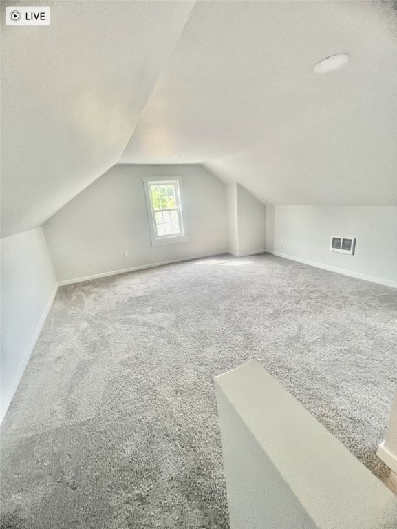 bonus room with carpet floors and vaulted ceiling