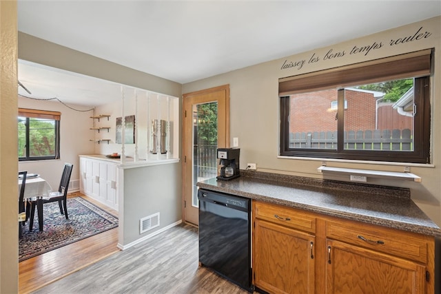 kitchen featuring dishwasher, wood-type flooring, and plenty of natural light