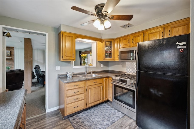 kitchen with stainless steel appliances, backsplash, sink, carpet, and ceiling fan