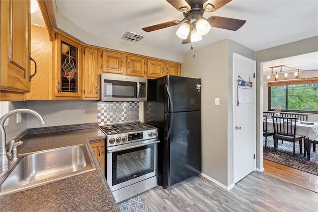 kitchen featuring light hardwood / wood-style floors, stainless steel appliances, sink, tasteful backsplash, and ceiling fan