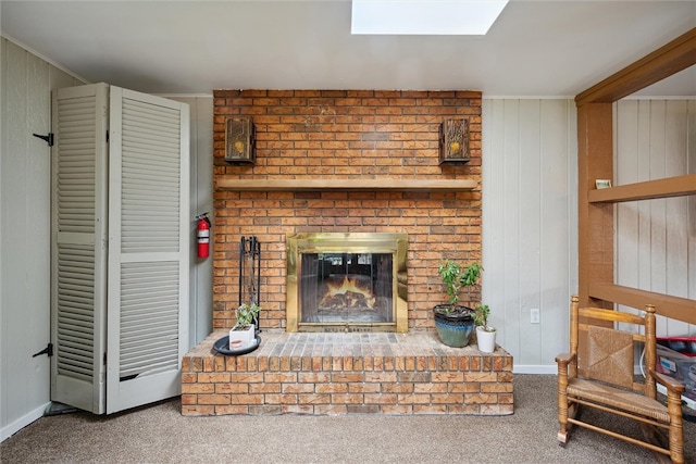 carpeted living room featuring a brick fireplace and a skylight