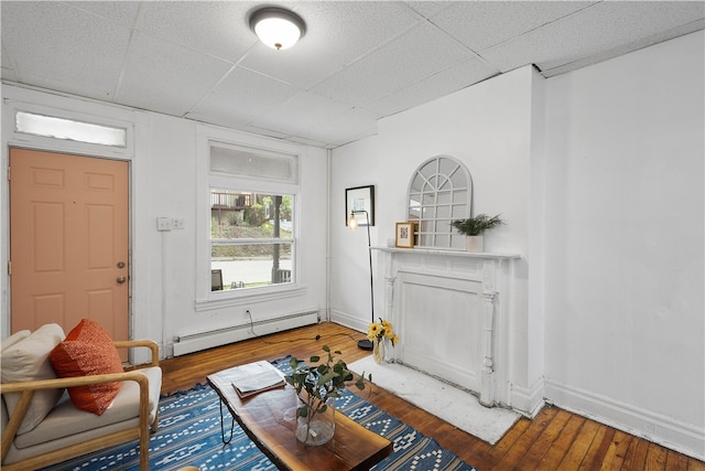 living room with hardwood / wood-style floors, a baseboard radiator, and a paneled ceiling