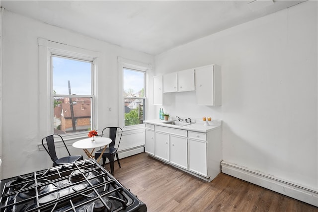 kitchen featuring a baseboard radiator, stove, light wood-type flooring, white cabinets, and sink