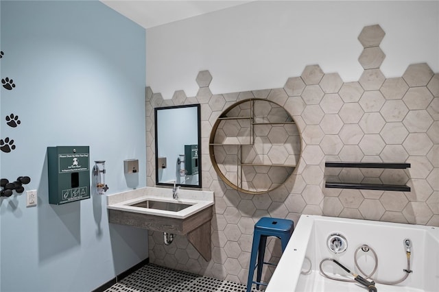 bathroom with tile patterned floors, a tub, and sink