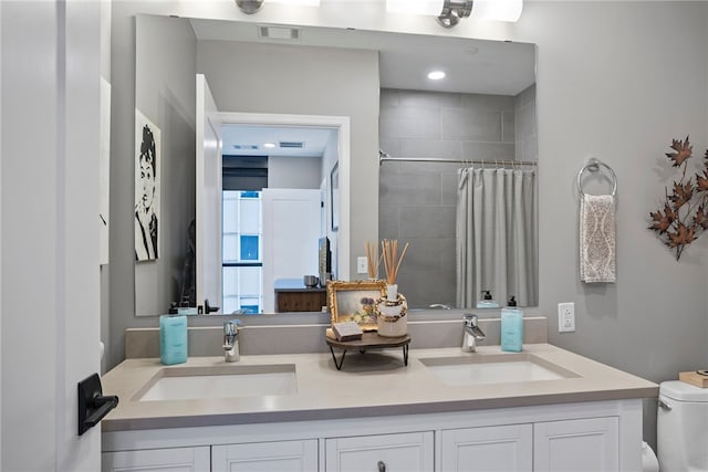 bathroom featuring curtained shower, vanity, and toilet