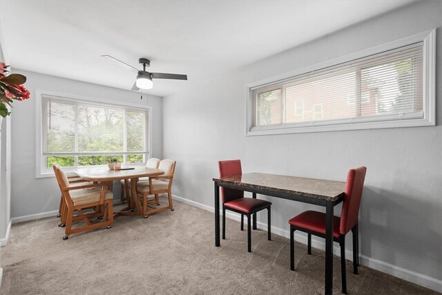 carpeted dining room featuring ceiling fan