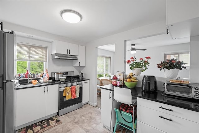 kitchen featuring appliances with stainless steel finishes, white cabinets, ceiling fan, and light tile floors