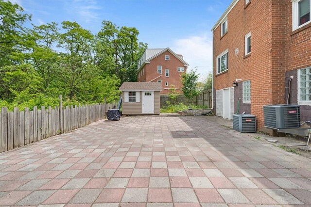 view of patio with a storage unit and central air condition unit