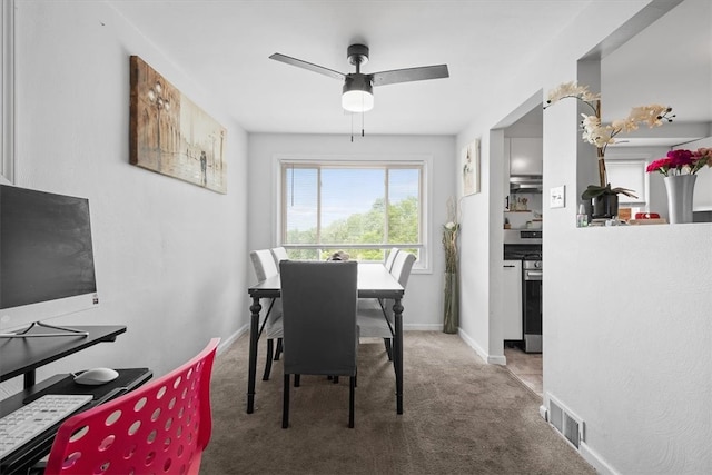 carpeted dining area with ceiling fan