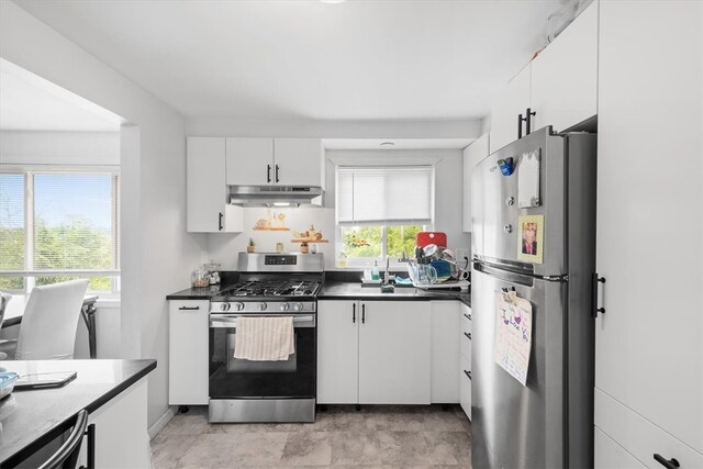 kitchen featuring stainless steel appliances, sink, white cabinetry, and light tile floors