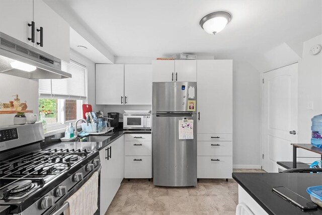 kitchen with sink, white cabinets, light tile floors, and stainless steel appliances