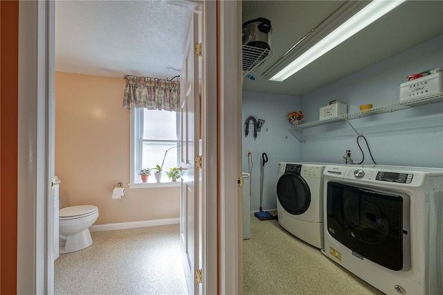 laundry area with a textured ceiling and washing machine and clothes dryer